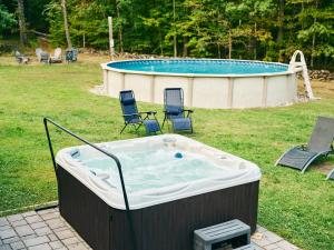 a hot tub in a yard with chairs and a pool at Visit Chill House 15 miles from Windham Hot Tub and Ping Pong in Cairo