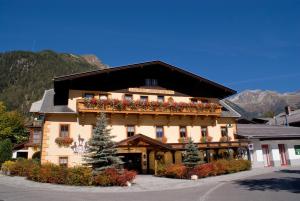 ein Gebäude mit Blumen an der Seite in der Unterkunft Hotel 3 Gemsen in Mallnitz