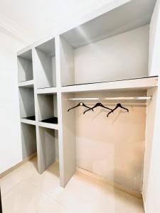 a walk in closet with white shelves at Golden Crystal Hotel in Accra +6 photos