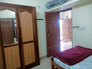 une chambre avec des portes en bois et un lit avec un drap violet dans l'établissement Aathi cottage, à Chinnakanal