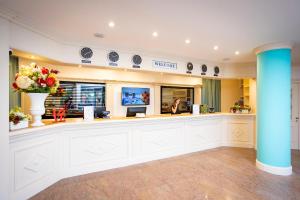 a large lobby with a reception counter with flowers at AN Hotel Milano San Donato in San Donato Milanese
