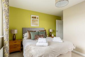 1 dormitorio con 1 cama grande y paredes verdes en About Tern - 10-Minute Walk to Poole Quay, with Harbour Views, en Poole