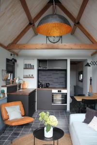 WoudrichemにあるBarnhouseのソファとキッチンのあるリビングルーム