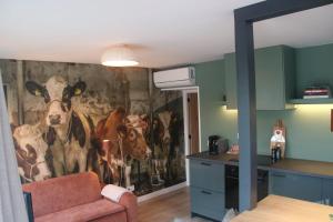a kitchen with a mural of cows on the wall at Hoeve Altena Barn-House in Woudrichem