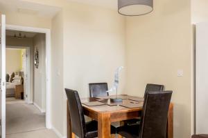 Un comedor con mesa y sillas de madera. en About Tern - 10-Minute Walk to Poole Quay, with Harbour Views, en Poole