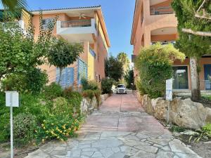 a car driving down a sidewalk next to a building at The Garden & Pool Townhouse in Paphos City