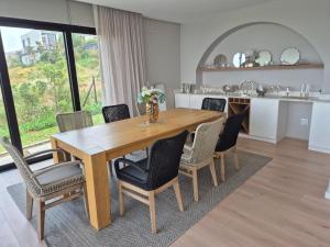 a kitchen and dining room with a wooden table and chairs at Modern Luxury Beach Villa in Ballito
