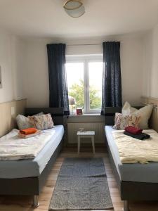 two beds in a room with a window at Ferienwohnung Dresden West in Dresden