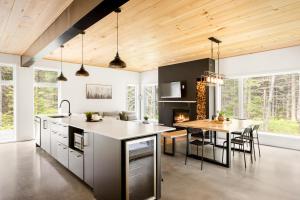 a kitchen with a table and a dining room at Le chalet ALTO - Nature & Détente in Saint-Alexis-des-Monts