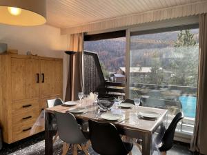 une salle à manger avec une table et des chaises ainsi qu'une grande fenêtre dans l'établissement Appartement 3 pièces, 6 couchages - Chantemerle, Serre-Chevalier, balcon, parking, casier à ski - FR-1-330E-9, à Saint-Chaffrey