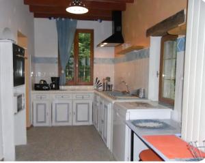 a large kitchen with white cabinets and a window at Gîte Madrelle in Lussault-sur-Loire