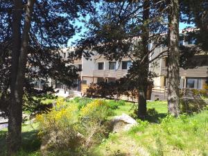 een gebouw met bomen en gras ervoor bij A l'orée des bois in Égat