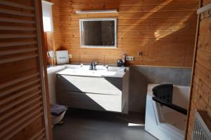 a bathroom with a sink and a mirror at 5 Sterne Ferienhaus Annika mit Kamin, Seeblick und großer Terrasse in Rieden +19 photos