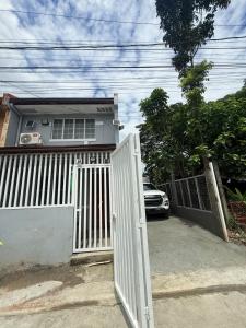 a white gate in front of a house with a car at Casa Tres - home in San Mateo 