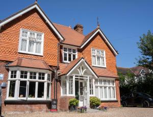 a house with an orange roof and white windows at Gatwick Turret Guest House in Horley