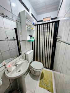 a bathroom with a white toilet and a sink at Casa do Marco&Leoni in Belém +1 photo