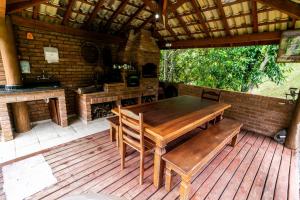 una mesa de madera y sillas en una terraza de madera en Chale Nossa Senhora Aparecida, en Cunha