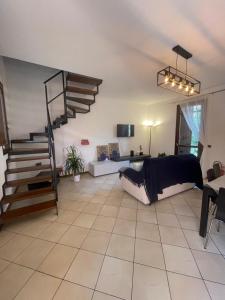 a living room with a spiral staircase and a couch at Entro le mura in Piacenza