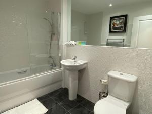 Un baño con inodoro, lavabo y ducha. en travelNess Apartment, en Inverness 22 fotos más