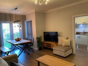Una sala de estar con una mesa de comedor y un televisor. en travelNess Apartment, en Inverness