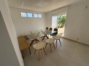 a dining room with a glass table and chairs at Villatella in Burriana