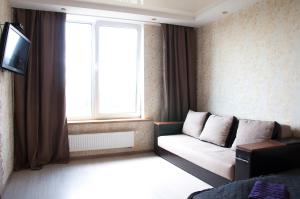 a living room with a couch and a window at Apartment on Bogatyrskaya 6a in Kyiv