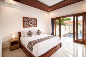 a bedroom with a bed and a large window at Doa Ubud Villa in Ubud