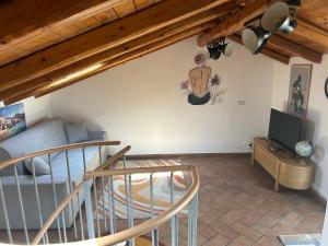 Una sala de estar con un sofá y un televisor. en The Cannizzaro Home, en Aci Castello