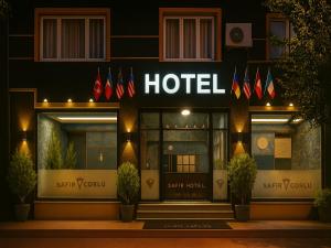 乔尔卢Çorlu Safir Hotel & City Center的一家在晚上在前面有标志的酒店