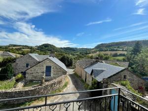 a view from a balcony of a village with stone buildings at La petite maison in Sévérac d' Aveyron