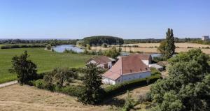 eine Luftaufnahme eines Hauses auf einem Feld mit einem Fluss in der Unterkunft Domaine en bord de saone in Pagny-le-Château