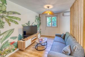 a living room with a blue couch and a tv at Shanis - Cozy Appartement sur Pérouges-Meximieux in Pérouges