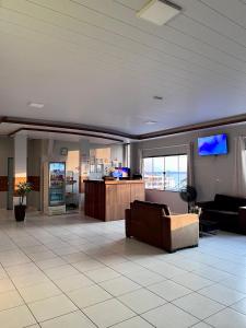 a lobby with a couch and a flat screen tv at Saymon Hotel in Portel