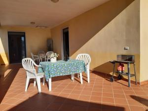 a dining room with a table and white chairs at cascina dei peri in Castelnuovo Magra