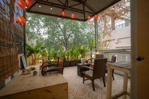 ハノイにあるTreelings Coffee & Home, Old Quarter, Food Streetのテーブルと椅子のある屋外パティオ