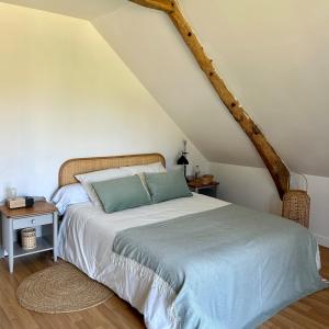 a bedroom with a bed with a blue pillow at Maison Onze calme en bord de Rance in Plouër-sur-Rance