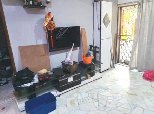 a living room with a tv and a table at 欢唱名宿 in Kluang