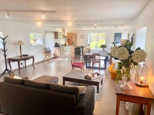 a living room with a couch and a table at Maison Onze calme en bord de Rance in Plouër-sur-Rance