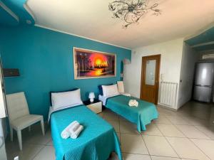 una camera da letto con due letti e una parete blu di Casa Marciano Costa D'Amalfi a Vietri