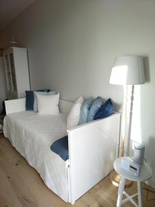 a bedroom with a white bed with blue pillows at Albatross Apartment Sea in Ķesterciems +26 photos