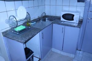 Una pequeña cocina con fregadero y microondas. en Dreams Studio Apartments - Deira, en Dubái 9 fotos más
