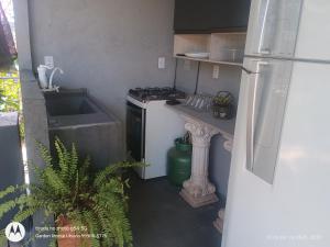 a small kitchen with a stove and a refrigerator at Flat no Garden III in Rondonópolis +5 photos