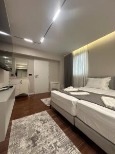 a bedroom with a large bed and a kitchen at Renev Apartments Tirana in Tirana +23 photos