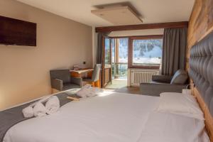 a hotel room with a large bed and a desk at Hotel Gran Roc in Sestriere