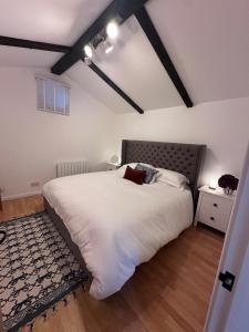 a bedroom with a large white bed and a rug at Charming 2-bed cottage in Peover, Cheshire East in Marthall