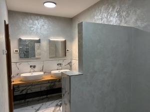 a bathroom with two sinks and two mirrors at Schöne Ferienvilla Morena Mit Pool in Kaštel