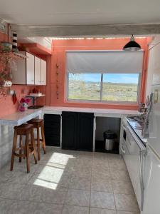 a kitchen with red walls and a window and a sink at La Celeste casa de playa in Las Grutas +12 photos
