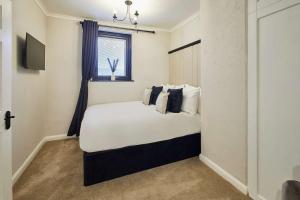 a bedroom with a large white bed with a window at Great Ayton Townhouse Retreat-Sleeps 6-3Bed-2Bath in Great Ayton