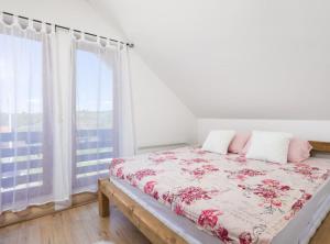 a white bedroom with a bed with pink pillows at Holiday Home Elizabeta in Slunj +45 photos