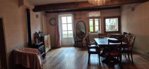 a dining room with a table and chairs at Domaine de la Fée-Licité in Jullié